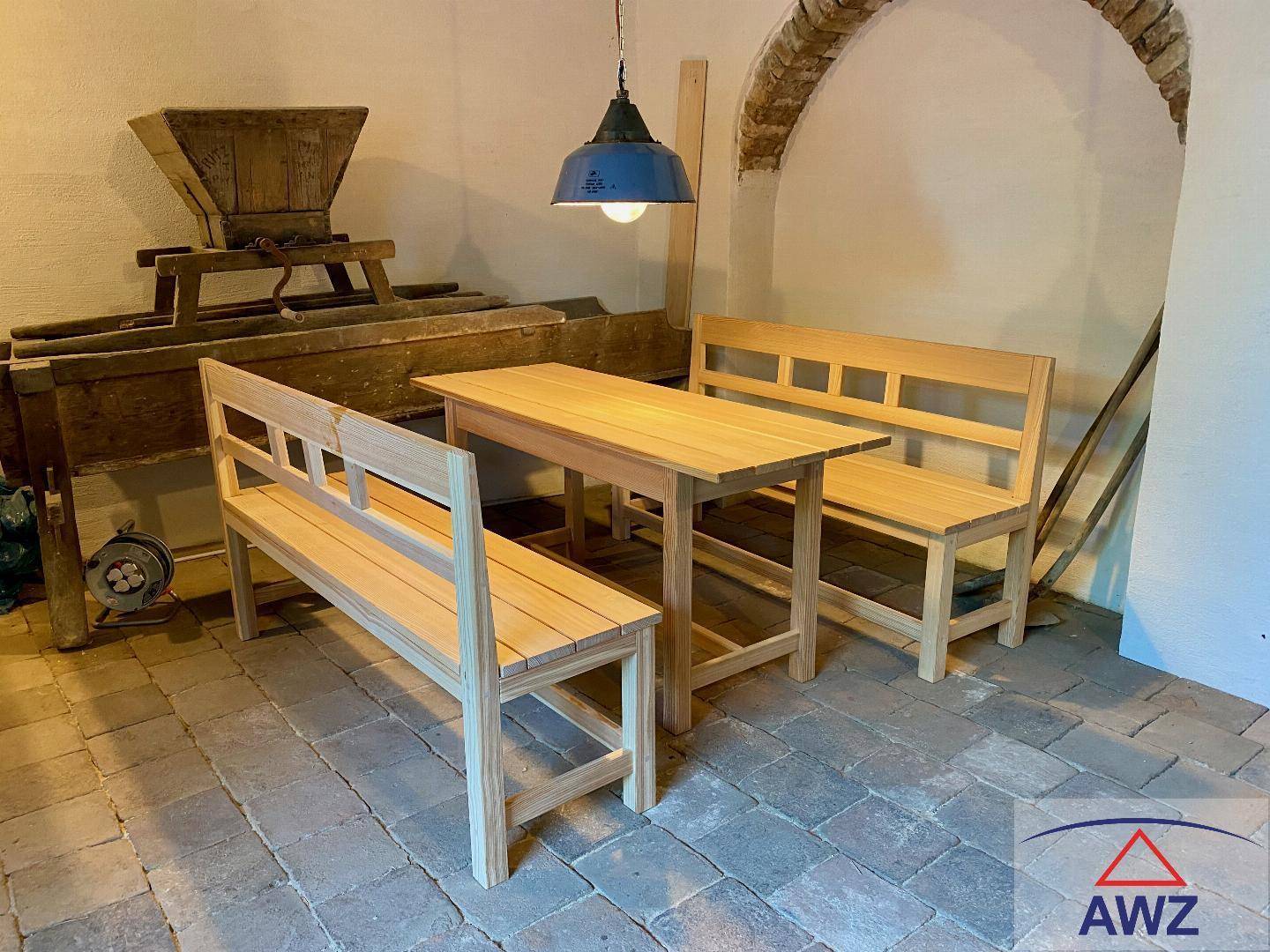 Detailansicht des Holztisches und der Bänke in einem rustikalen Ambiente mit Ziegelboden.