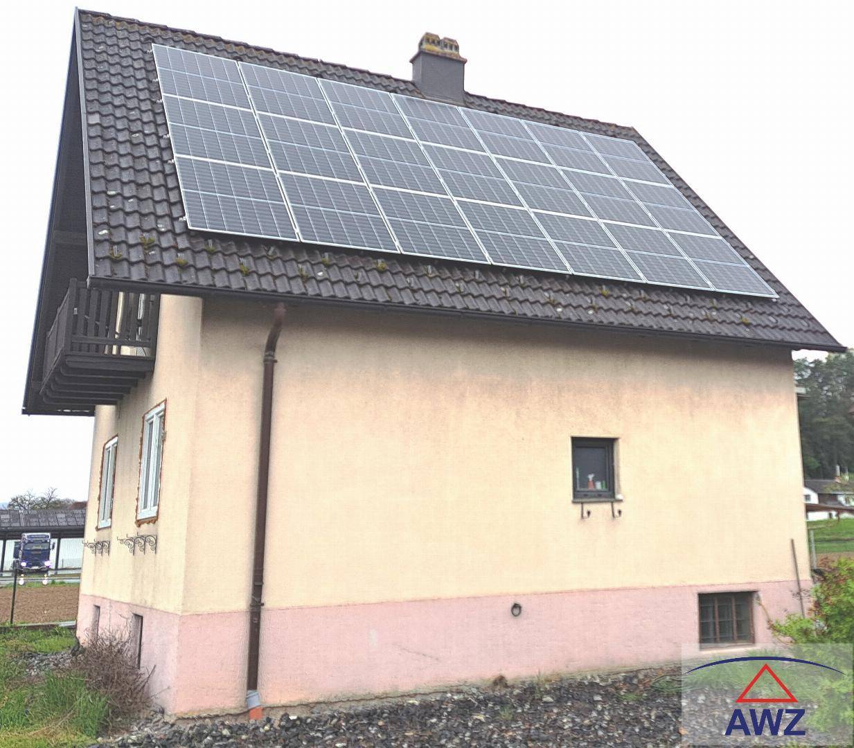 Rückansicht des Hauses mit Photovoltaikanlage auf dem Satteldach und kleinem Balkon.
