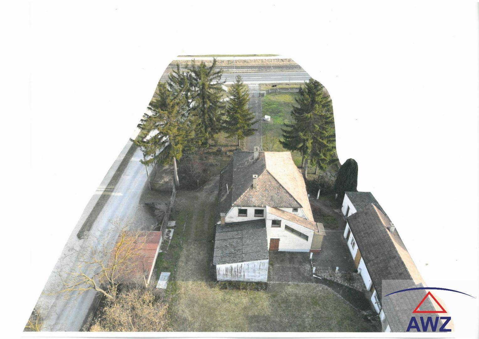 Vogelperspektive des Hofes mit Wohnhaus, Scheunen und angrenzender Straße.