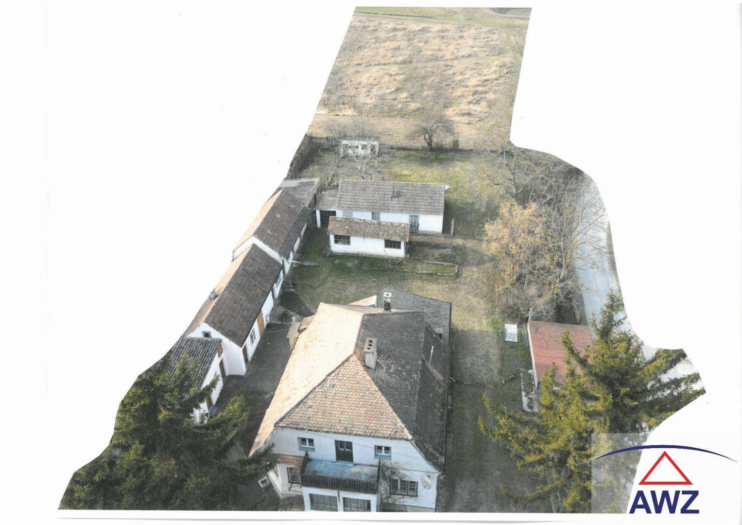 Gesamtansicht des Anwesens aus der Luft mit Wohnhaus, Nebengebäuden und angrenzendem Feld.