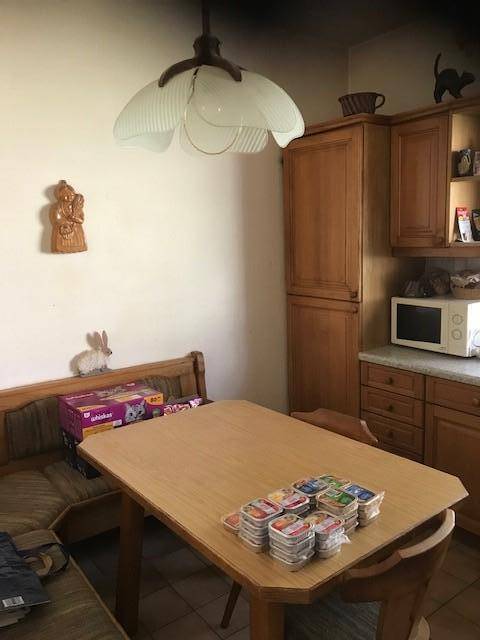 Kleine Küche mit Holzeinbauten, Mikrowelle und gemütlicher Essecke.