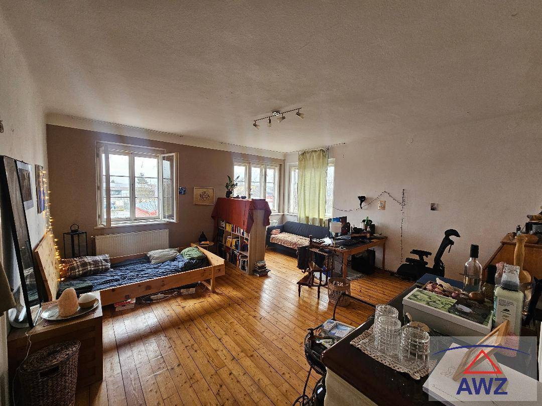 Geräumiges Zimmer mit Bett, Schreibtisch und mehreren Fenstern, das vielseitig nutzbar ist.
