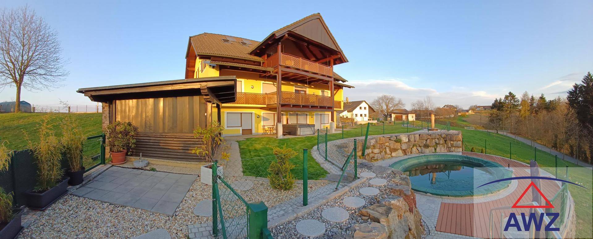 Panoramablick auf das gelbe Haus mit Poolbereich und gepflegtem Garten.