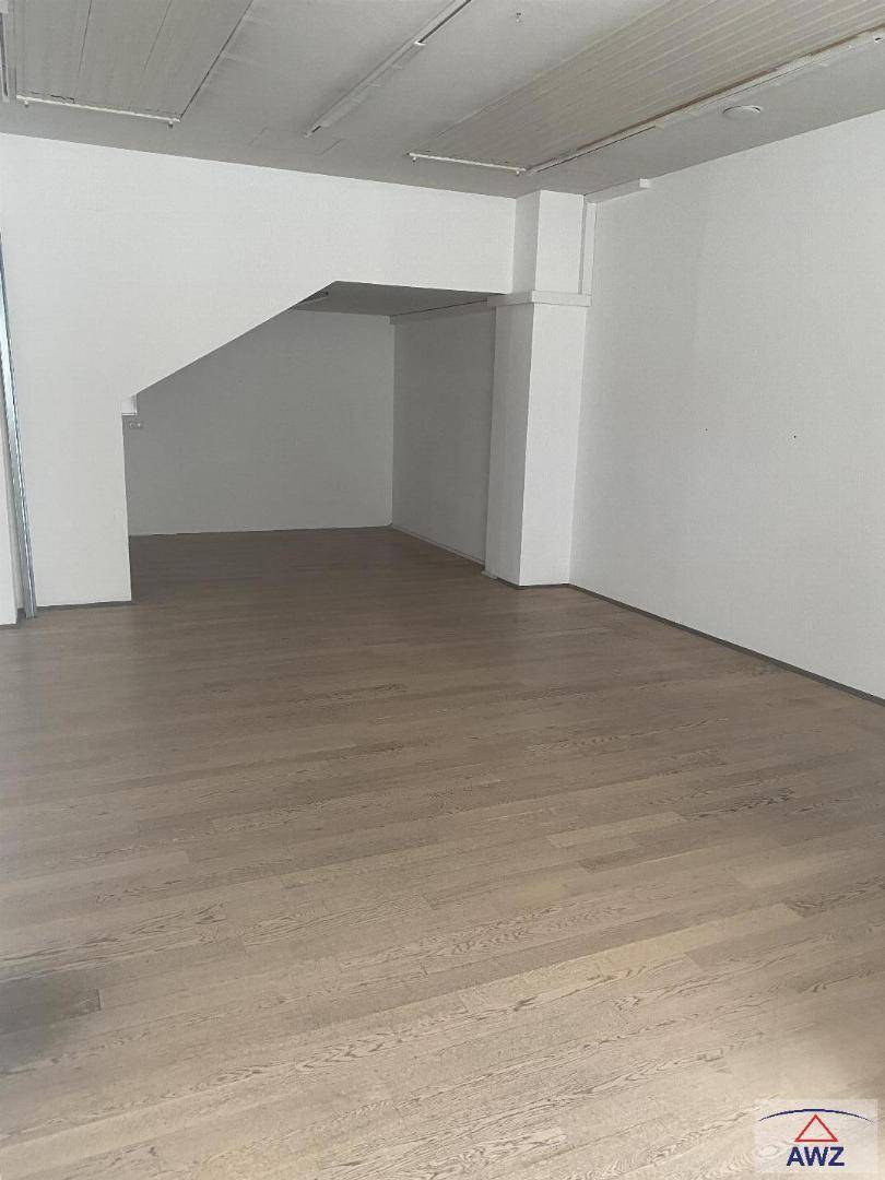 Leerer, heller Raum mit weiß gestrichenen Wänden und modernem Holzboden.