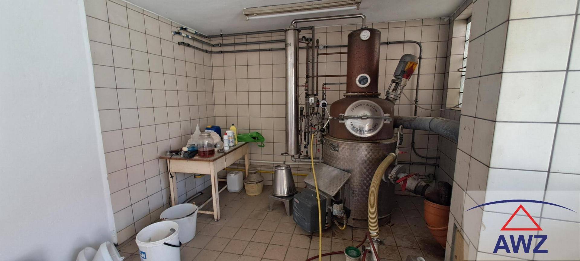 Funktionaler Wirtschaftsraum mit gefliesten Wänden und industrieller Ausrüstung.