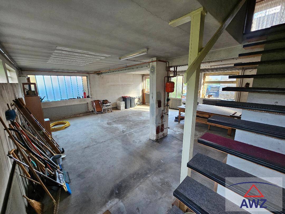 Geräumiger Keller oder Garagenbereich mit Betonboden, einer Treppe und viel Platz für Lagerung.