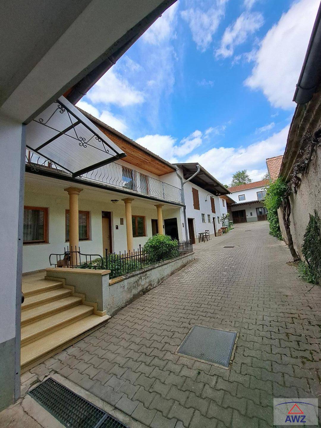 Weitläufiger gepflasterter Innenhof umgeben von mehreren Gebäuden unter blauem Himmel.