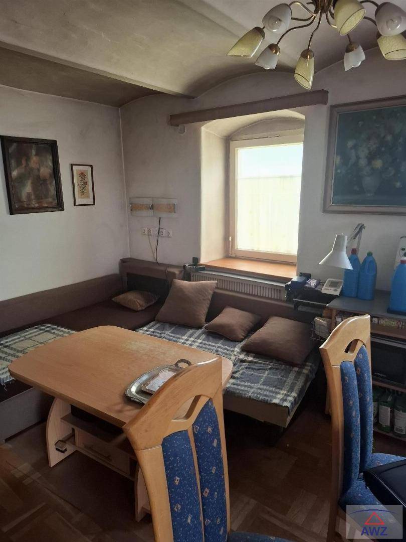 Gemütlicher Wohn-Essbereich mit Holztisch, Eckbank und einem Fenster für natürliches Licht.