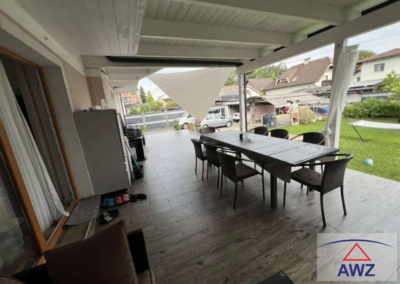 Überdachte Terrasse mit Esstisch und Stühlen, ideal für Mahlzeiten im Freien mit Gartenblick.