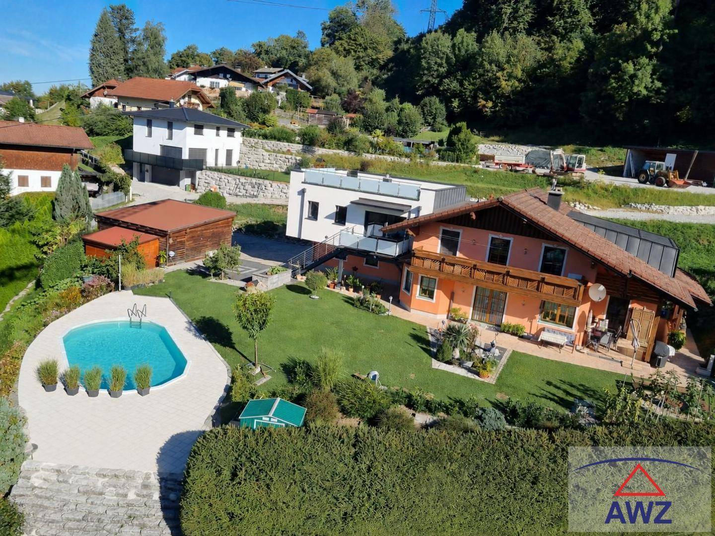 Luftaufnahme eines Anwesens mit großem Garten, Swimmingpool und umliegender Wohnbebauung.