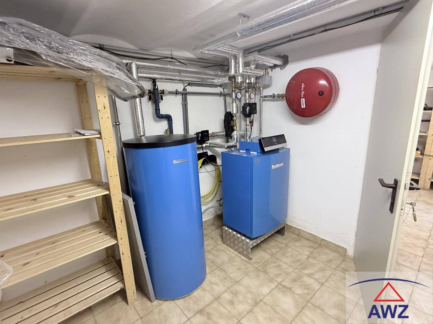 Sauberer Heizungsraum im Keller mit moderner Heizungsanlage und Warmwasserspeicher.