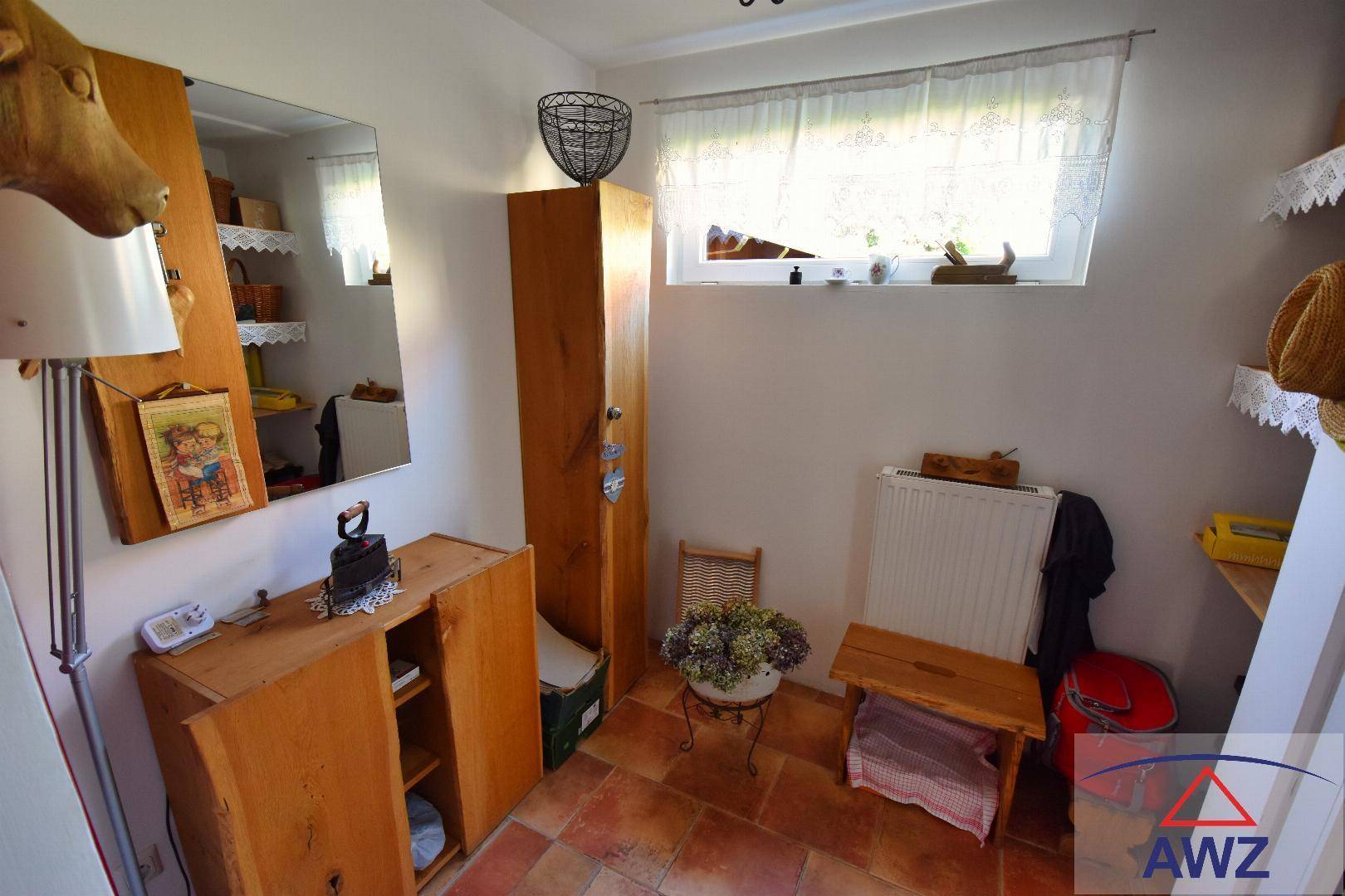 Kleiner Raum mit Terrakottafliesen, Fenster und rustikalen Holzmöbeln.