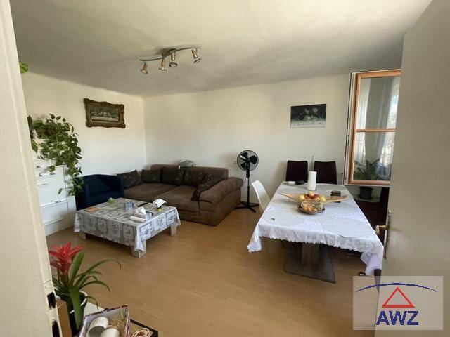 Geräumiger Wohn-Essbereich mit Sofa, Esstisch und hellem Holzboden.