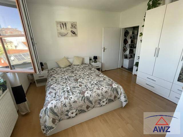 Helles Schlafzimmer mit Doppelbett, weißem Kleiderschrank und Holzboden.