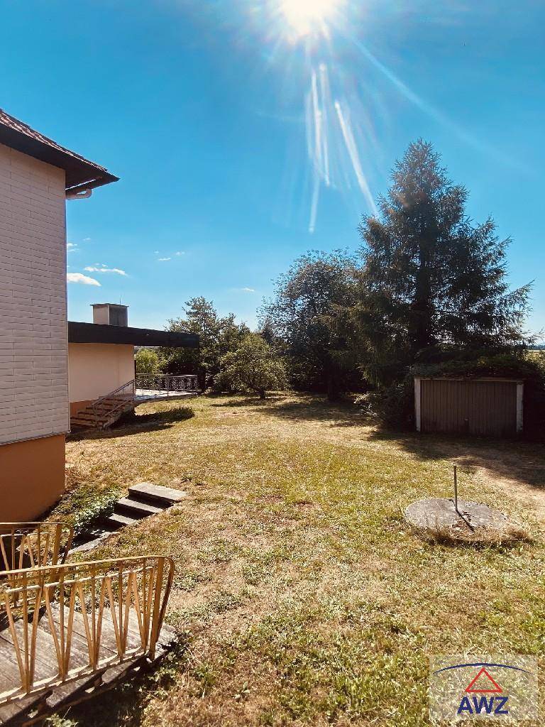 Seitenansicht des Hauses mit Garten, Außentreppe und einem kleinen Geräteschuppen.