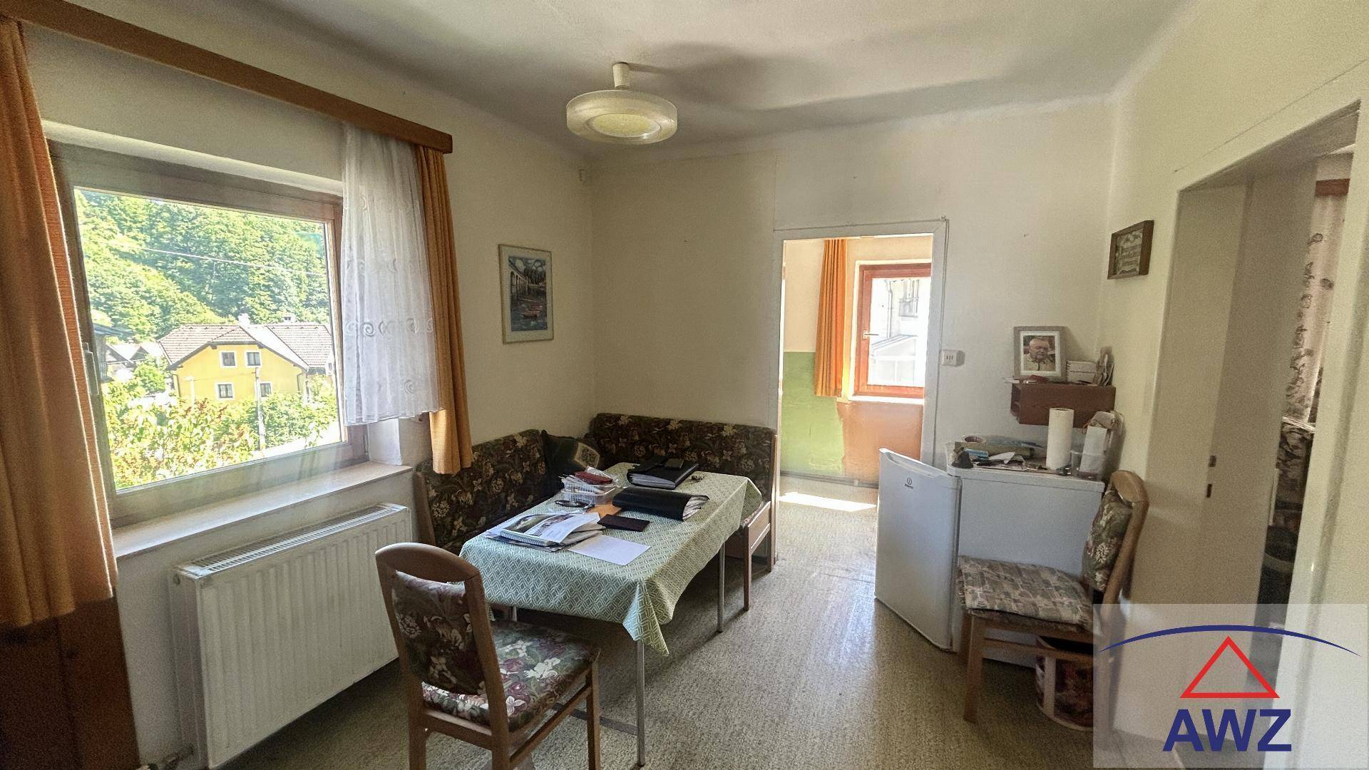 Heller Essbereich mit Tisch, Sitzbank und Blick aus dem Fenster auf die umliegende Landschaft.