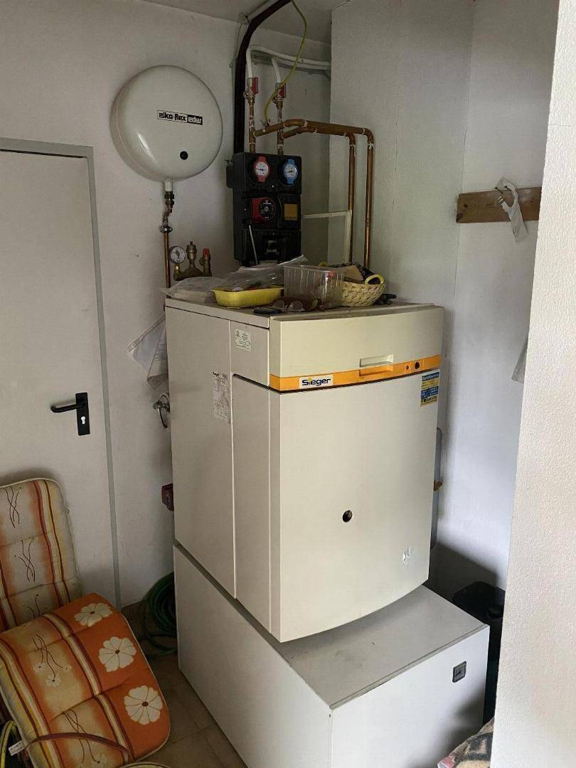 Hauswirtschaftsraum mit Heizungsanlage, Warmwasserspeicher und Platz für weitere Geräte.