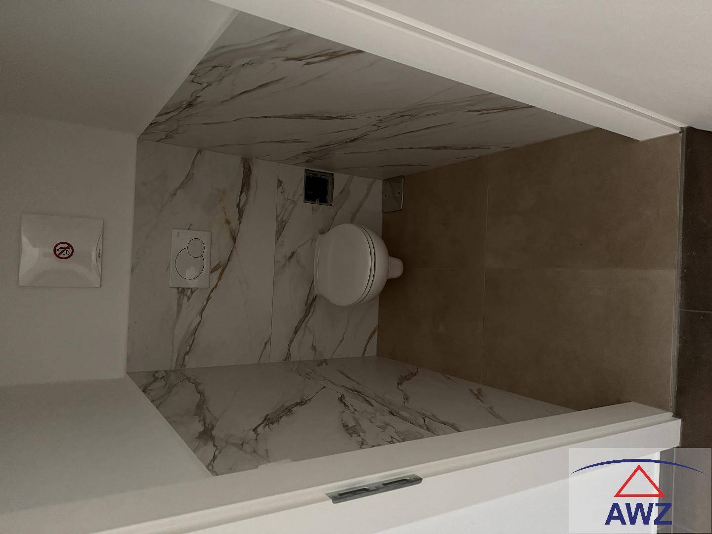 Modern gefliestes WC mit Wand-WC und eleganten Marmoroptik-Fliesen.