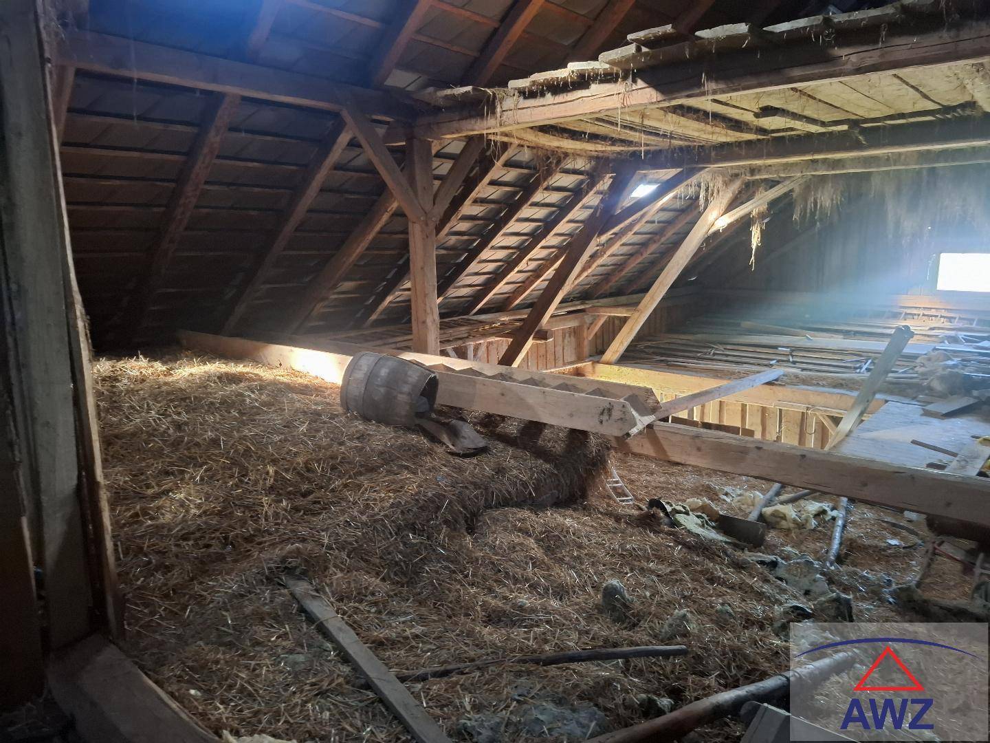 Geräumiger Dachboden mit Holzbalken und Stroh, bietet viel Stauraum und Ausbaupotenzial.