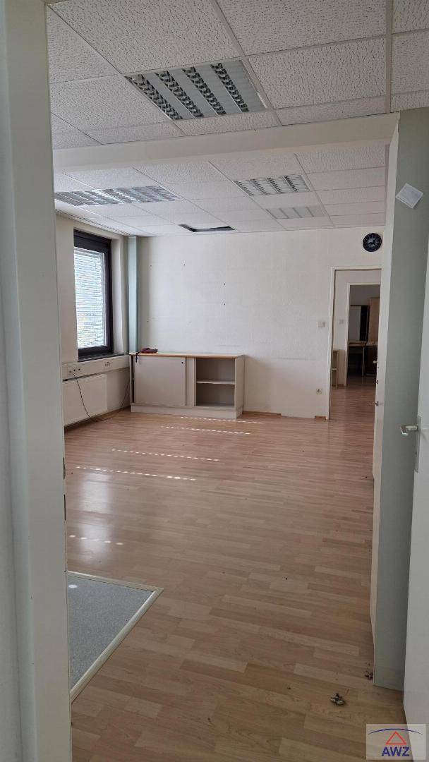 Heller Büroraum mit Laminatboden und Fenster, bietet flexible Nutzungsmöglichkeiten.