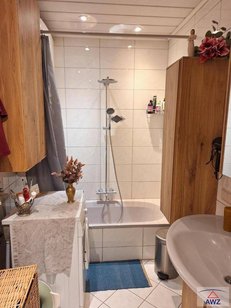Kleines Badezimmer mit Badewanne, Duschfunktion und weißen Fliesen.