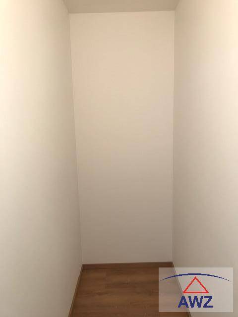Schmaler, leerer Raum mit Laminatboden, ideal als Abstellraum oder begehbarer Kleiderschrank.