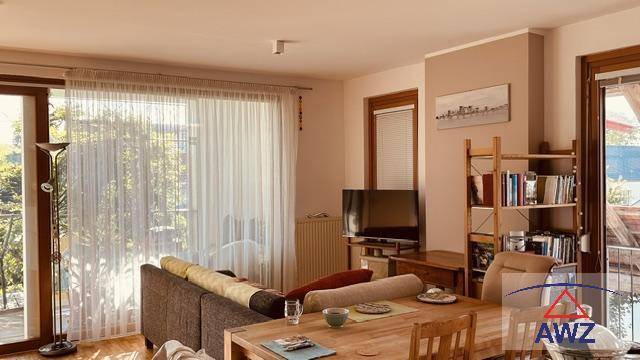 Heller Wohn- und Essbereich mit Holztisch, Sofa und Zugang zum Außenbereich.