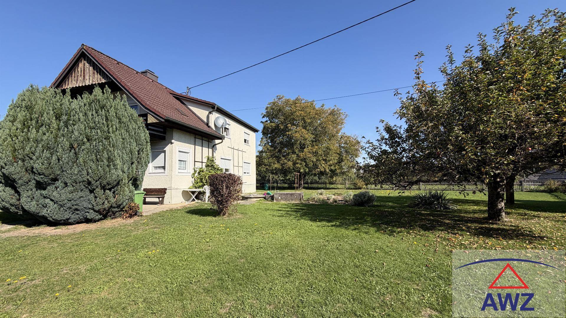 Weitläufiger Garten mit Rasenfläche und Obstbäumen neben dem Einfamilienhaus.