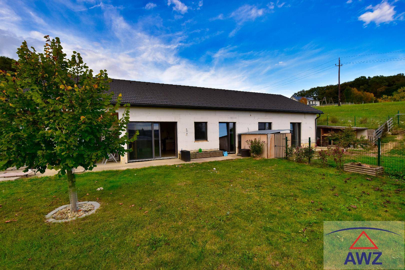 Modernes Einfamilienhaus mit großem Garten und Blick auf die umliegende Landschaft.
