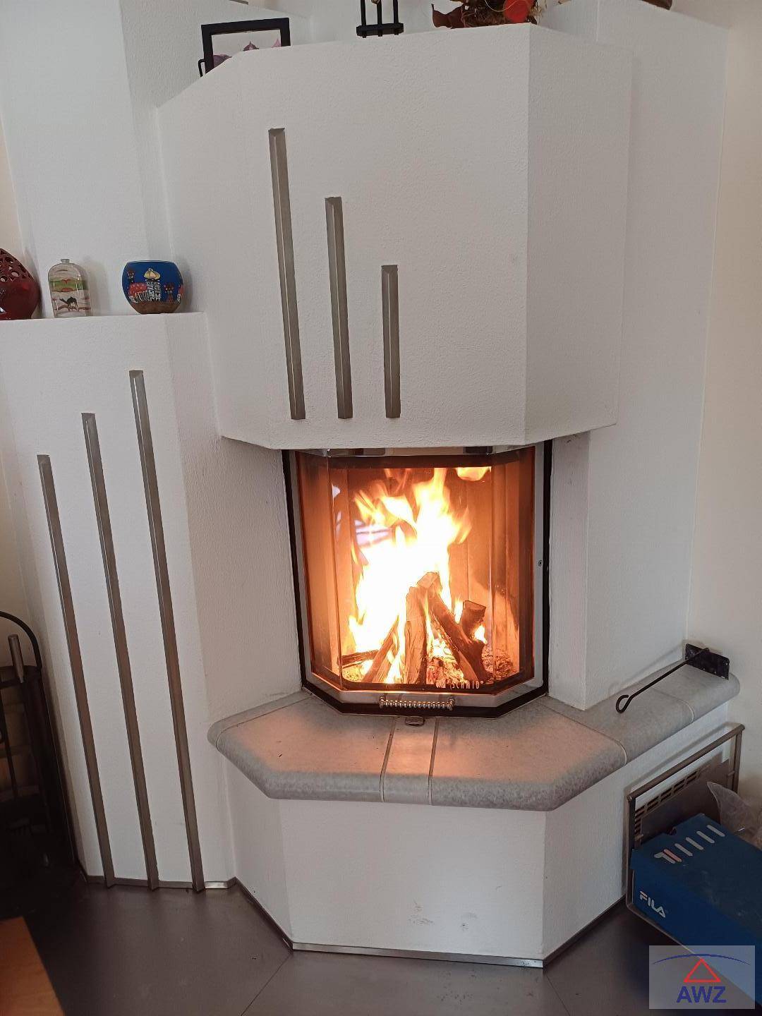Nahaufnahme eines traditionellen Kachelofens mit sichtbarem Feuer, der Wärme und Gemütlichkeit spendet.