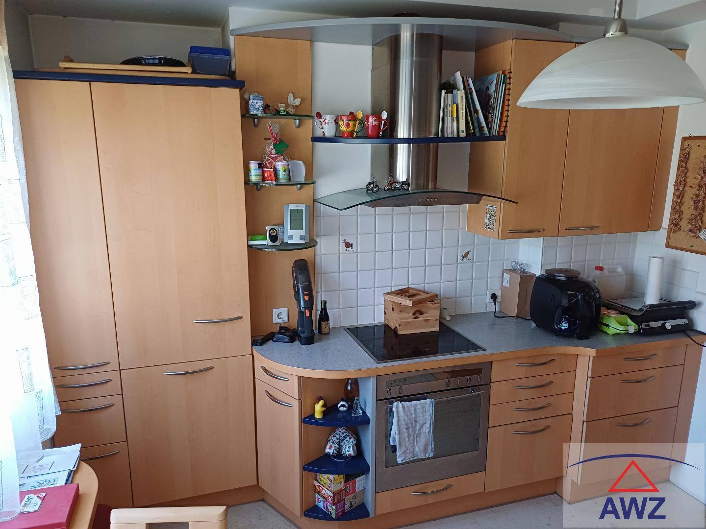Funktionale Einbauküche mit hellen Holzfronten, integrierten Geräten und Dunstabzugshaube.