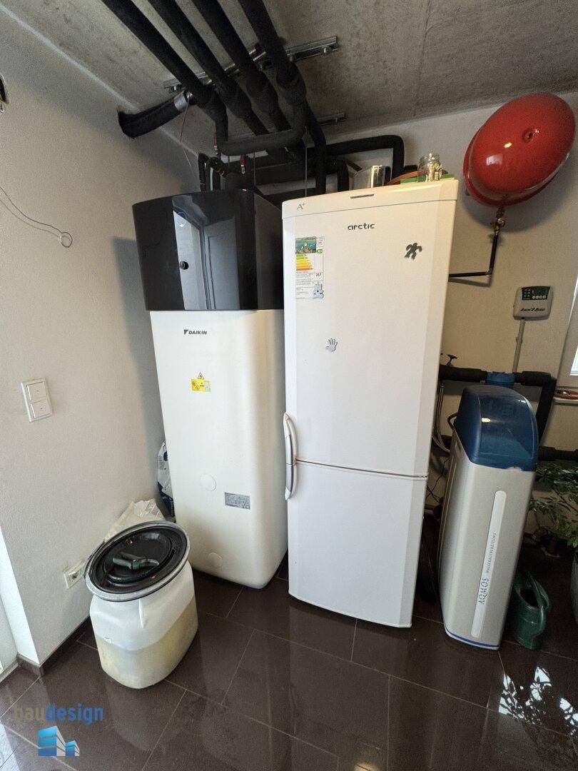 Technikraum mit Wärmepumpe, Warmwasserspeicher und weiteren Installationen für das Gebäude.