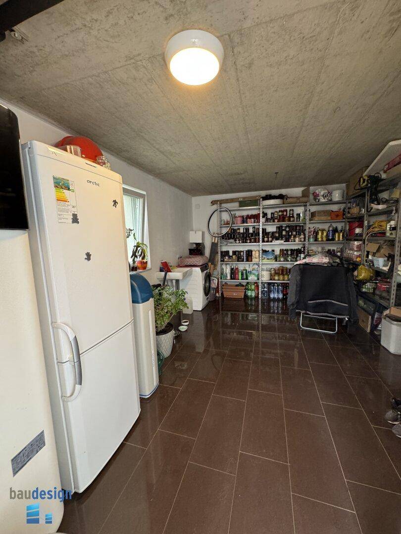 Geräumiger Abstellraum mit Regalen, Waschmaschine und Technikgeräten für den Haushalt.