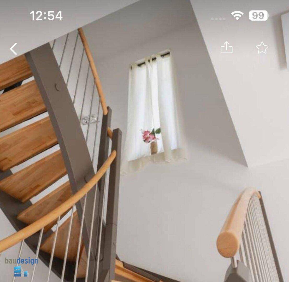 Moderne Holztreppe mit Metallgeländer und einem kleinen Fenster im Treppenhaus.