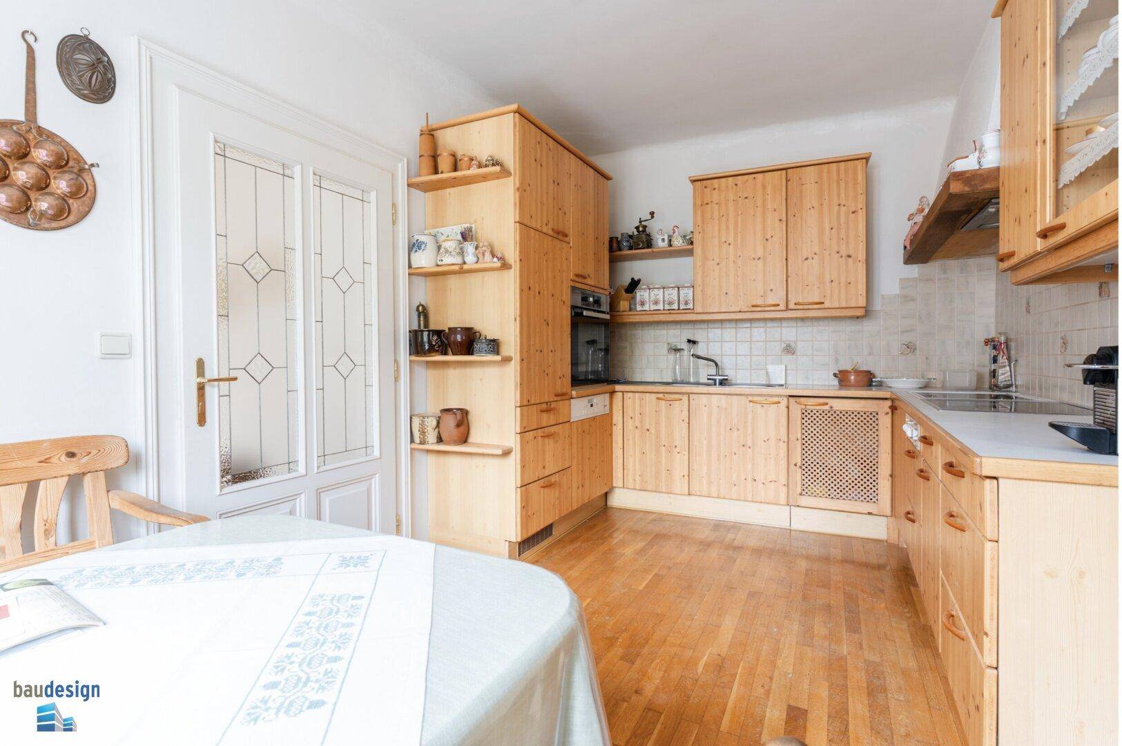 Gemütliche Holzküche mit Essbereich, Einbaugeräten und viel Stauraum.