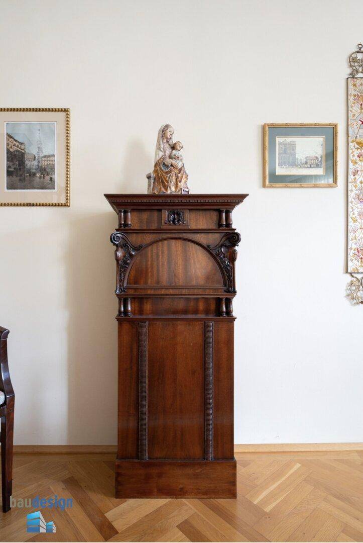 Antiker Holzschrank im Esszimmer mit kunstvollen Schnitzereien und Dekoration.