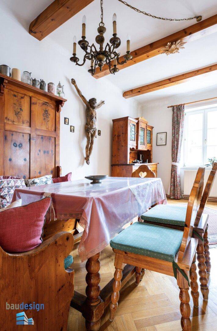 Detailansicht des Essbereichs mit Holztisch, Stühlen und Kronleuchter.
