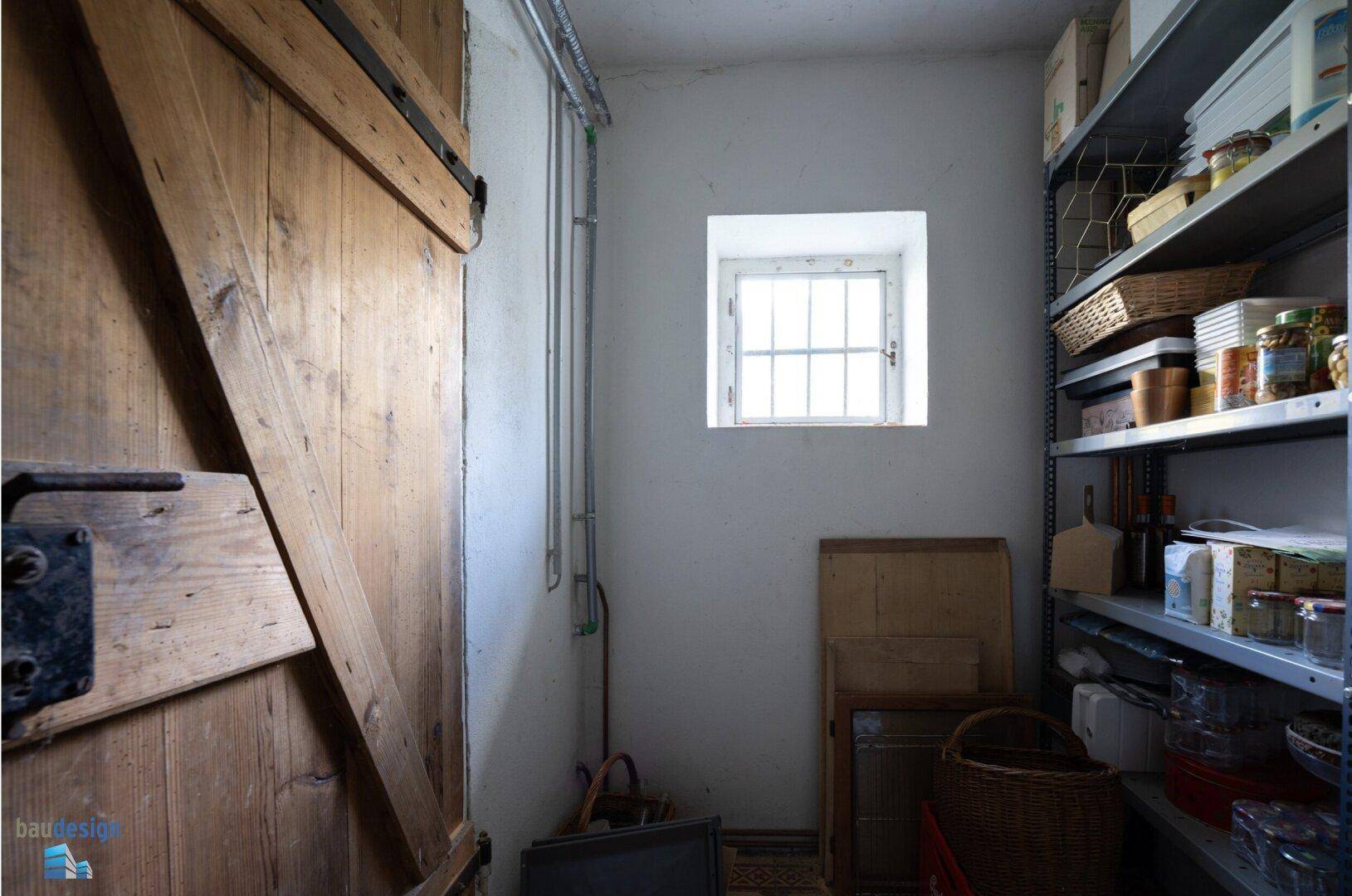 Praktischer Abstellraum mit Regalen, kleinem Fenster und Holztür.