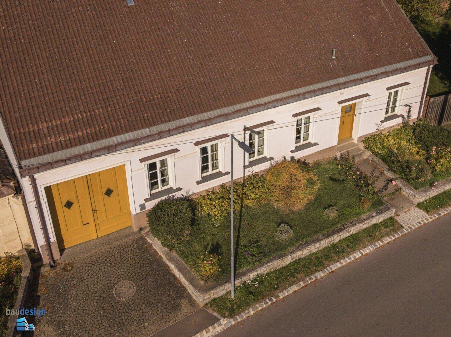 Luftaufnahme des Hauses mit Vorgarten, Einfahrt und Satteldach.