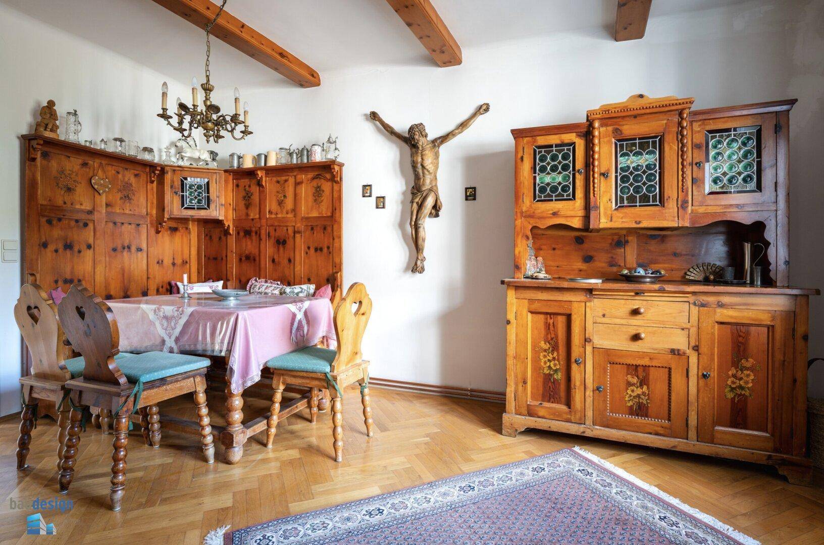 Geräumiger Essbereich mit Holzbalken, Parkettboden und traditionellen Schränken.