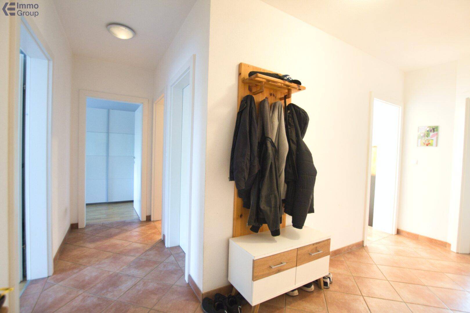 Heller Flur mit Terrakottafliesen und einer Garderobe, die zu weiteren Räumen führt.