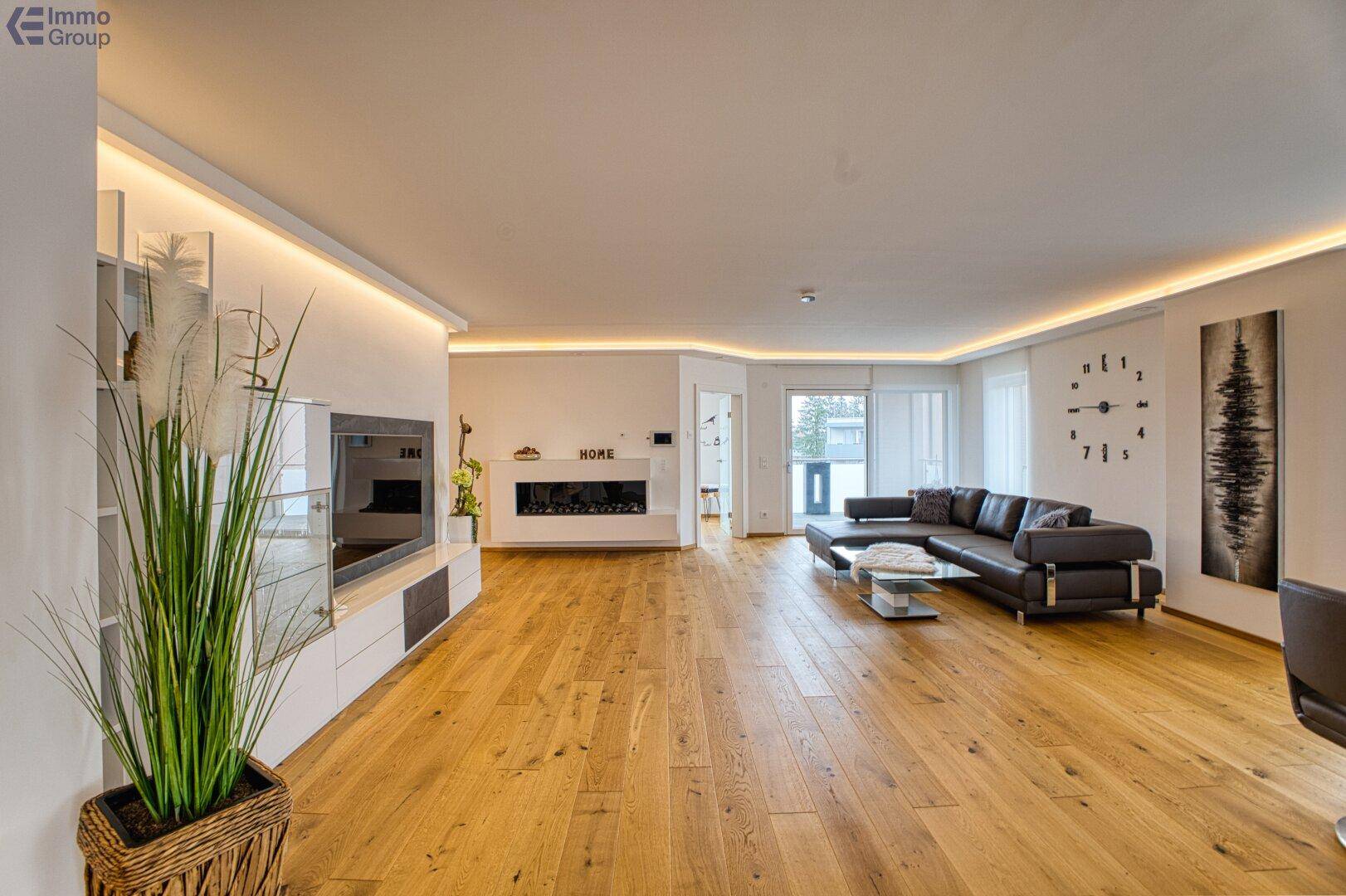Großzügiges Wohnzimmer mit bequemer Couch, modernem TV-Möbel und integriertem Kamin.