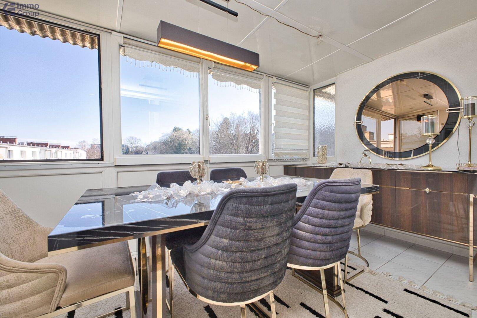 Eleganter Essbereich mit großem Tisch, bequemen Stühlen und weitem Ausblick durch große Fenster.