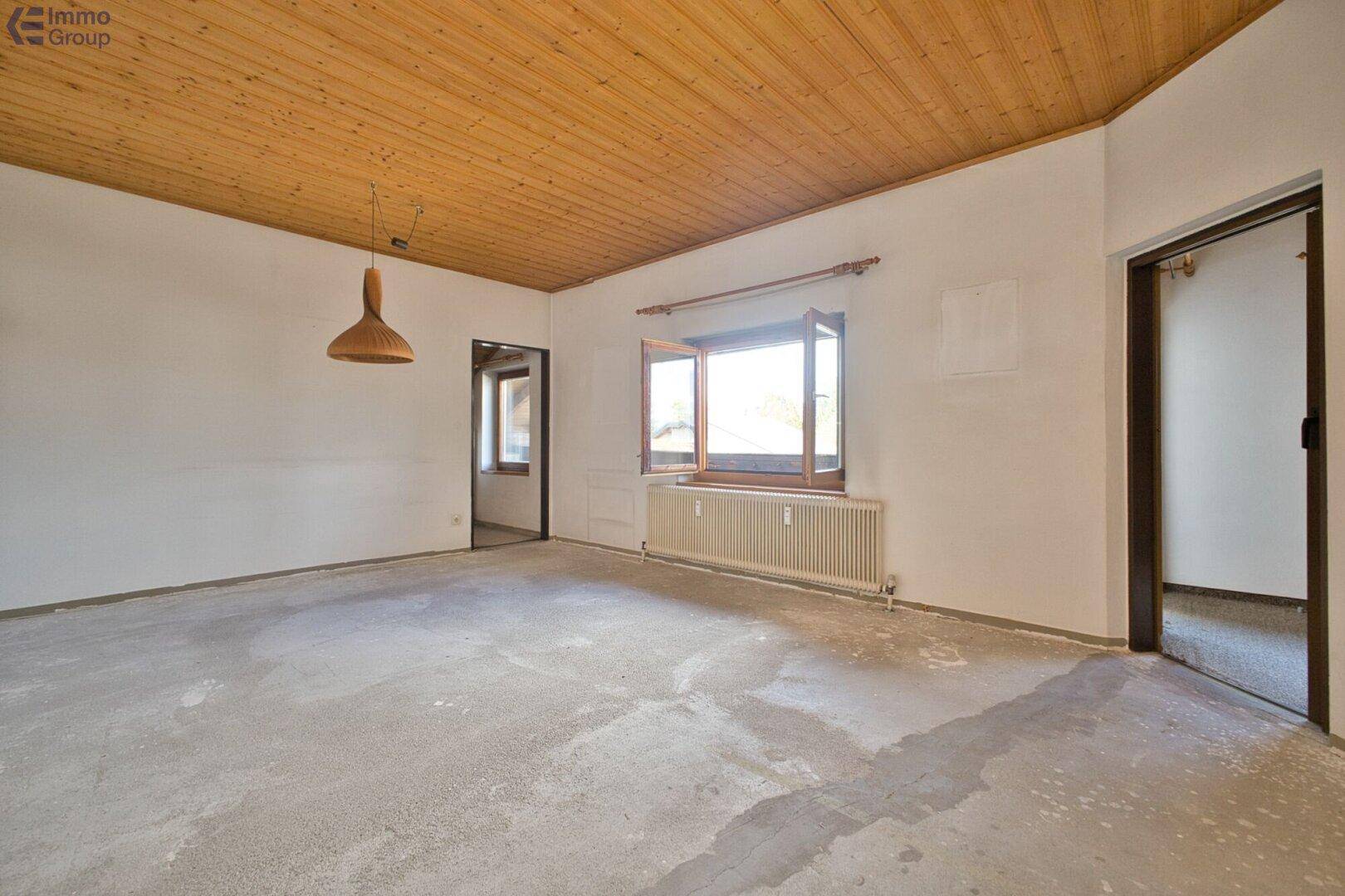Geräumiger, leerer Raum mit Holzbalkendecke und großen Fenstern, ideal zur individuellen Gestaltung.