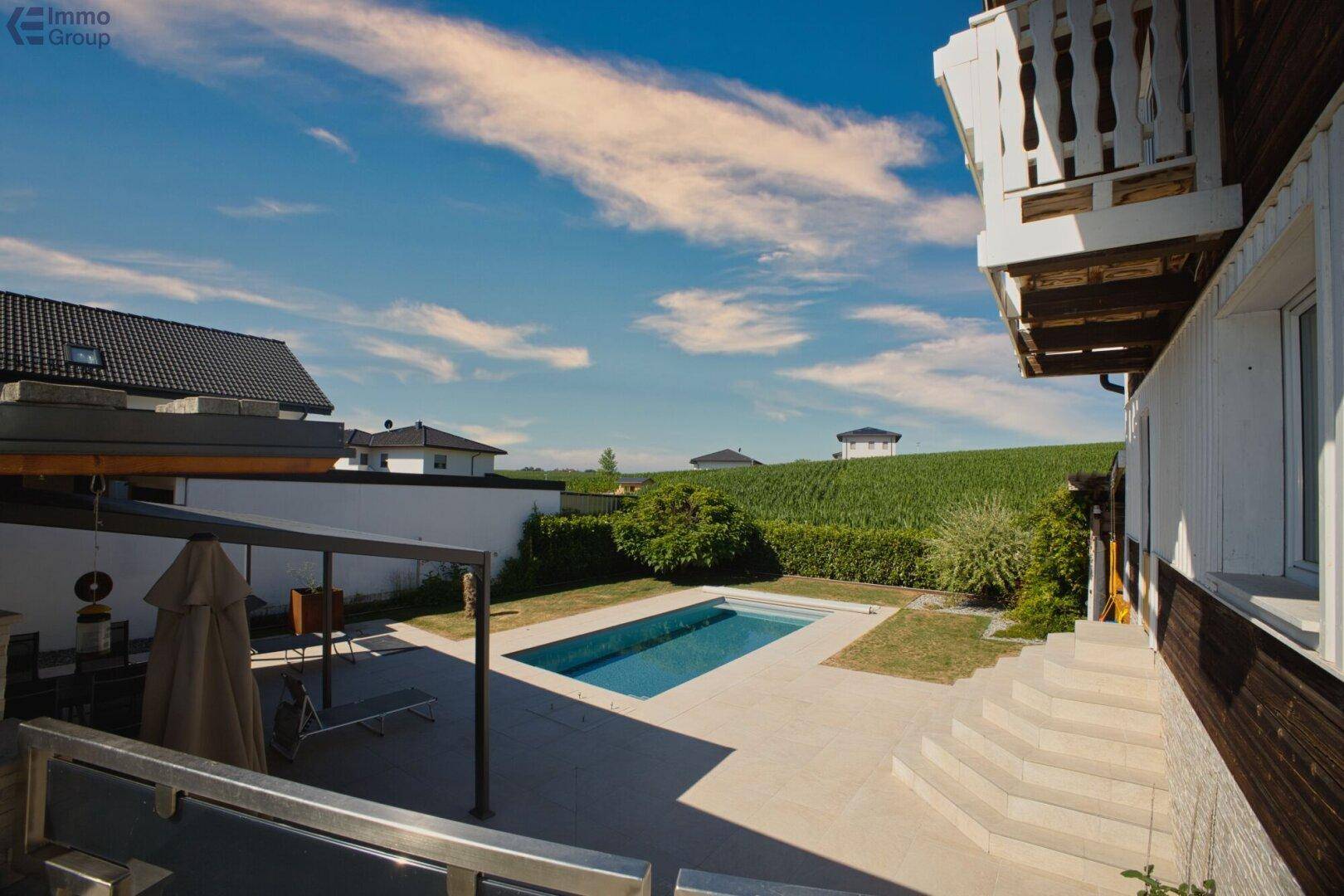 Weitläufiger Außenbereich mit Pool, Terrasse und Blick auf die umliegende Landschaft.