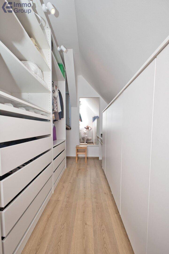 Geräumiger begehbarer Kleiderschrank mit viel Stauraum und Spiegelfläche.