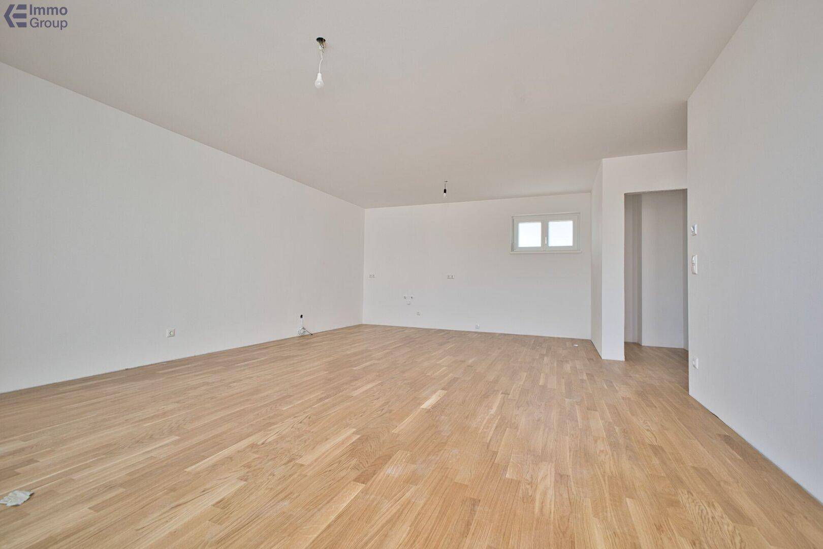 Geräumiger, heller Raum mit Holzparkett und einem kleinen Fenster, ideal für Schlafzimmer oder Büro.
