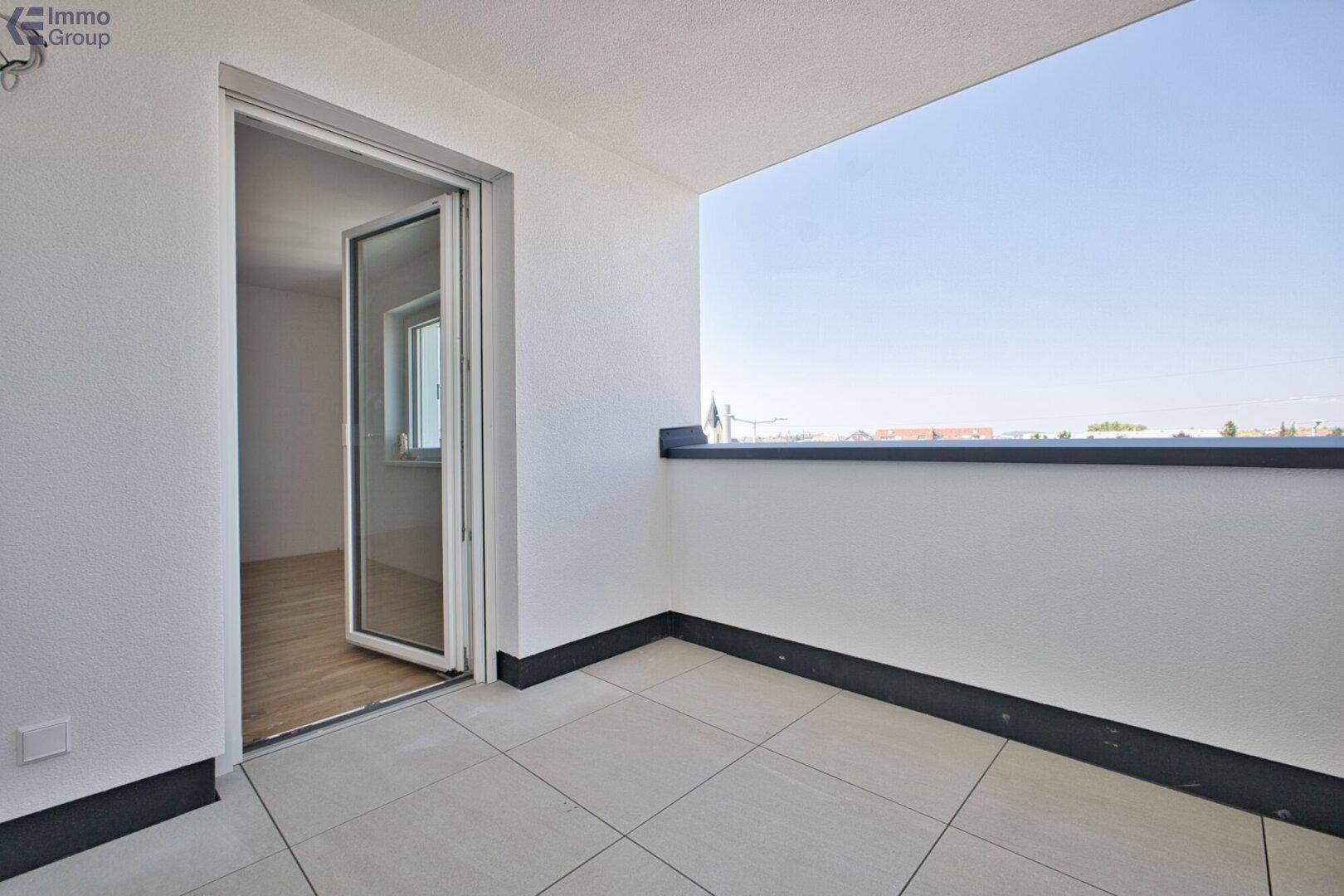 Heller Balkon mit Fliesenboden und weitem Blick, bereit für individuelle Gestaltung.