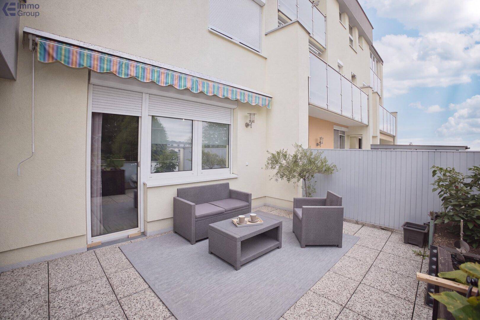 Gemütliche Terrasse mit Sitzgelegenheiten und Markise, ideal für entspannte Stunden im Freien.