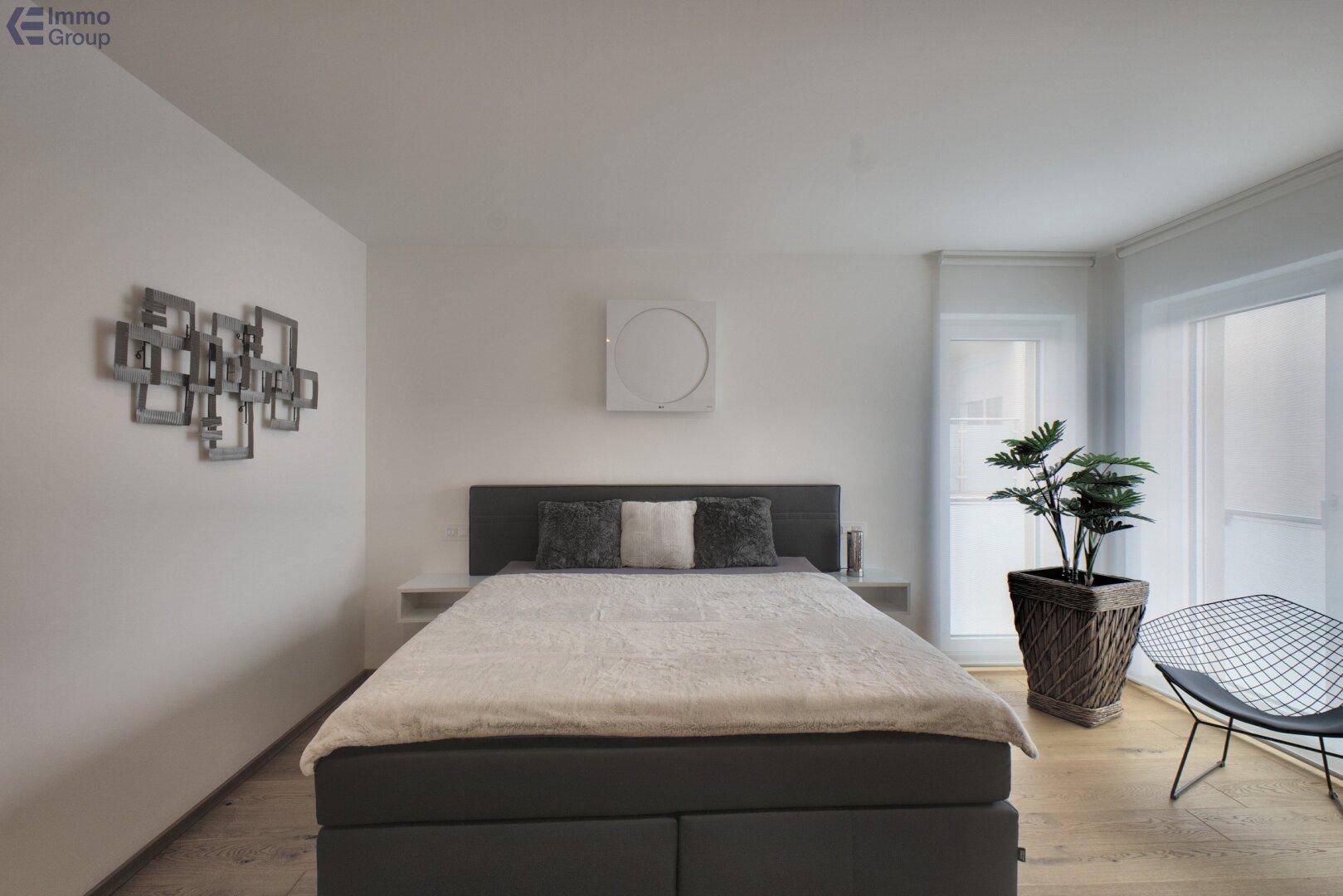 Helles Schlafzimmer mit komfortablem Doppelbett, Holzboden und moderner Einrichtung.